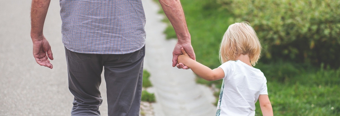 Symboldbild zu Familie und Hilfe: Grossvater hält die Hand der Enkelin